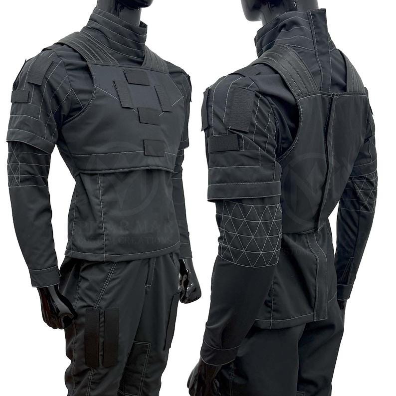 May include: Black tactical outfit with a high collar, featuring a vest-like top with rectangular patches and geometric stitching. The long-sleeved shirt and pants have pockets and are designed for a sleek, modern look. The outfit is displayed on a mannequin.