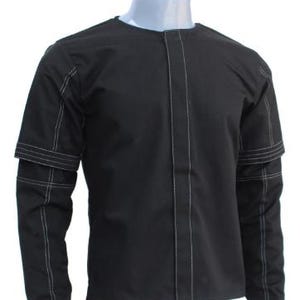 May include: Black long-sleeve shirt with white stitching details. The shirt features a round neck and a vertical seam down the front. The sleeves have a unique design with a layered look, and the stitching is visible.
