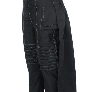 May include: Black pants with white stitching details. The pants feature a button closure, a pocket, and quilted knee panels. The pants have a unique design with a long, flowing panel on the side.