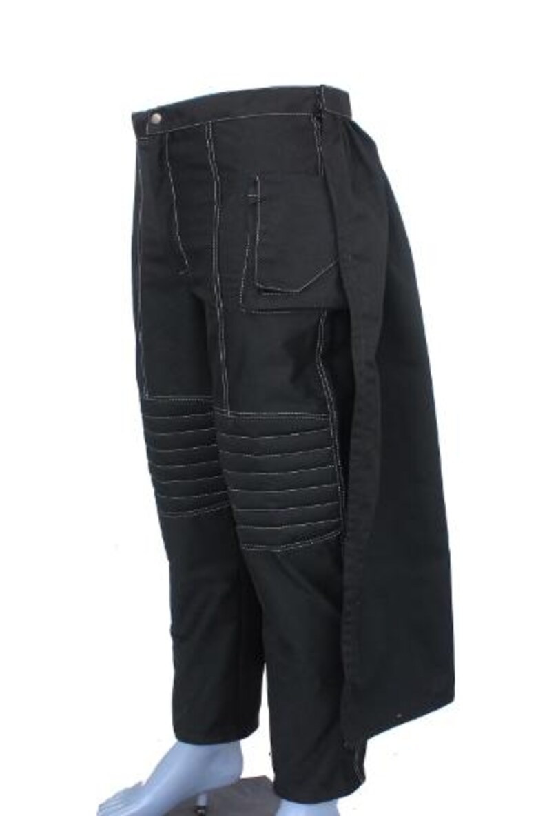 May include: Black pants with white stitching details. The pants feature a button closure, a pocket, and quilted knee panels. The pants have a unique design with a long, flowing panel on the side.