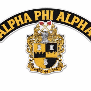 Może przedstawiać: Naszywka z napisem "ALPHA PHI ALPHA" w złotym kolorze na czarnym, zakrzywionym tle. Poniżej szczegółowy herb ze złotymi i czarnymi elementami, w tym tarczą i skrzyżowanymi pochodniami.