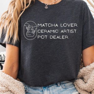 May include: A set of three ceramic mugs with a speckled, matte finish. The mugs are in shades of cream, light gray, and dark gray. Each mug has a simple, minimalist design, perfect for coffee or tea.