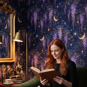 Op de afbeelding: Een persoon met rood haar leest een boek op een groene bank. De kamer heeft donkerblauw behang met een bloemen- en hemels ontwerp, met paarse blauwe regen, halve manen en sterren. Een goudomrande spiegel en lamp zijn ook zichtbaar.