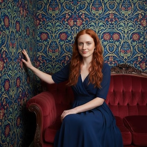 May include: A navy blue wrap dress with elbow-length sleeves and a flowing skirt. The dress features a V-neckline and a fitted waist, crafted from a solid-colored fabric that drapes down to the floor, creating a clean and simple silhouette.