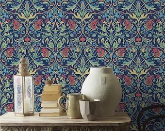 May include: A metal lantern, a stack of four books, a ceramic mug, and a large white vase sit on a carved wooden table against a dark blue wallpaper featuring a repeating pattern of red flowers, green leaves, and swirling yellow vines.