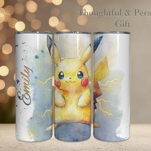 May include: A white tumbler featuring a watercolor illustration of Pikachu with lightning bolts. The tumbler has the name "Emily" in cursive. The text "Thoughtful & Personal Gift" is at the top.
