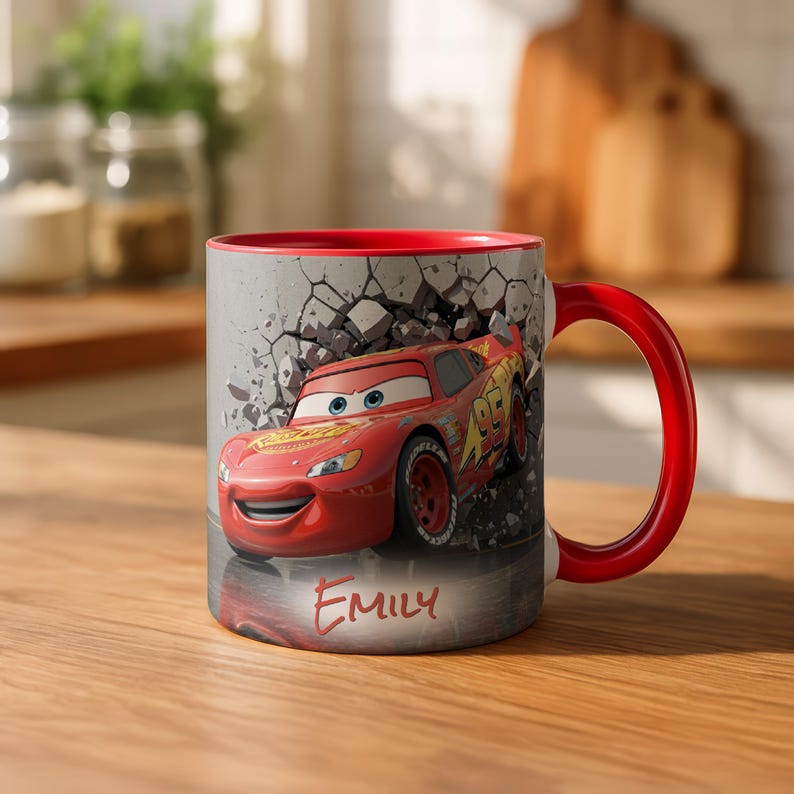 May include: Red ceramic mug featuring Lightning McQueen from the Cars movie, with a red interior and handle. The mug has a gray background with a cracked wall effect and the name "Emily" on the front.