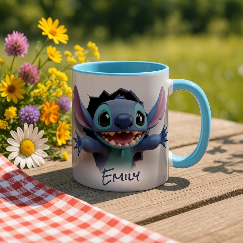 Puede incluir: Una taza de cer&aacute;mica blanca con interior y asa azules. La taza presenta un personaje de dibujos animados saliendo de un agujero, con el nombre "EMILY" escrito debajo. El fondo incluye flores y una mesa de madera.