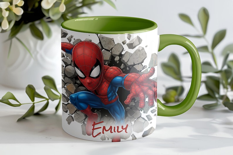 K&ouml;nnte beinhalten: Wei&szlig;e Keramik-Tasse mit einem Spiderman-Motiv, das durch eine Wand bricht. Innen und Henkel sind gr&uuml;n. Der Name "Emily" steht in roter Schrift auf der Vorderseite der Tasse.