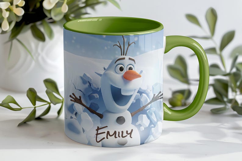 May include: A ceramic mug featuring Olaf from Frozen, with a green handle and interior. The mug has a light blue background with a snow scene and the name "Emily" written on it. The mug is decorated with a smiling Olaf.