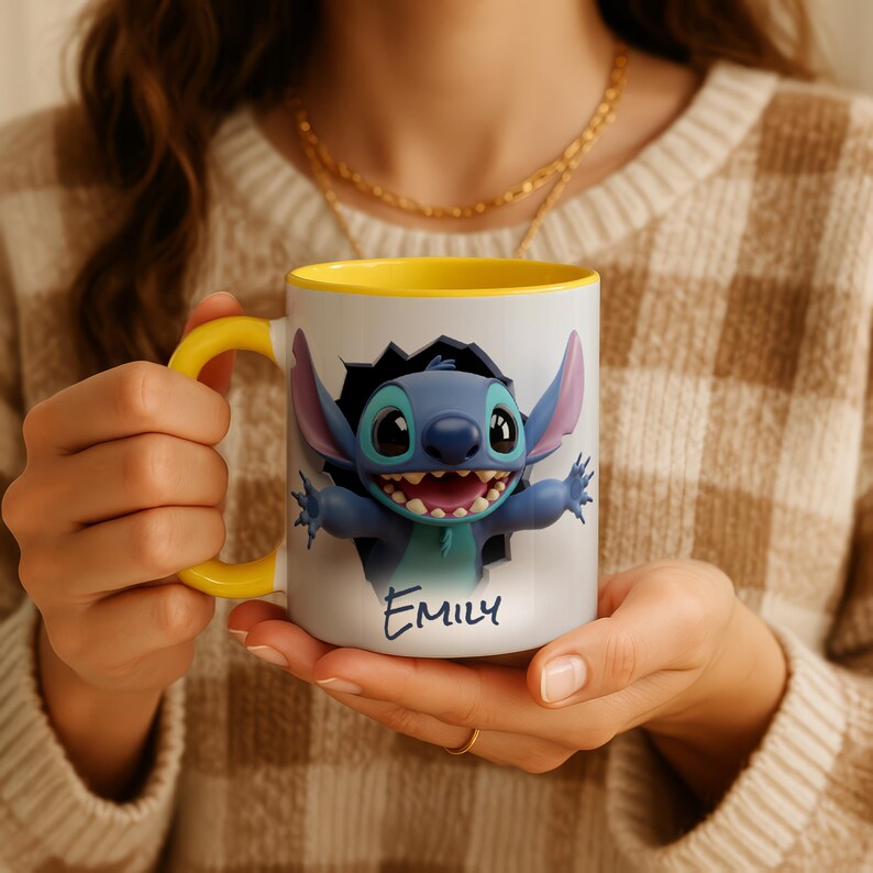 Puede incluir: Taza de cer&aacute;mica blanca con interior y asa amarillos. La taza presenta un dise&ntilde;o de personaje de dibujos animados azul con el nombre "Emily" en cursiva. El personaje tiene orejas grandes y una amplia sonrisa.