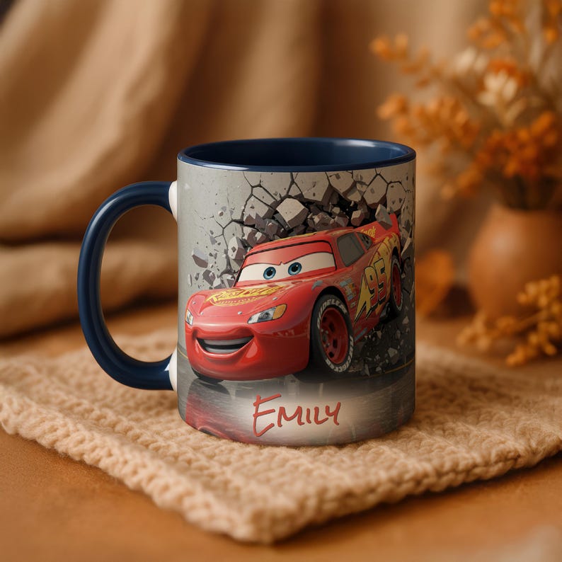 May include: A ceramic mug featuring Lightning McQueen from the Cars movie. The red mug has a blue handle and interior. The design shows McQueen breaking through a wall, with the name "EMILY" in red script below the car.