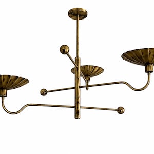 May include: A brass-toned metal chandelier featuring a central vertical rod with a circular ceiling mount. Three curved arms extend outward, each supporting a shallow, fluted, shell-shaped bowl. Two additional straight rods feature spherical ends.