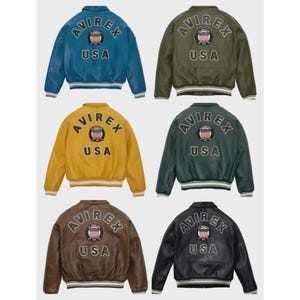 May include: Six leather bomber jackets in shades of blue, olive green, mustard, dark green, brown, and black. Each jacket displays the "AVIREX USA" logo on the back, with a crest. The jackets have ribbed cuffs and waistbands. The jackets are a classic style.