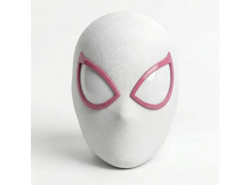 May include: A white mask with pink eye frames, resembling a superhero's mask. The mask has a textured surface and a pointed chin. The eye openings are white.