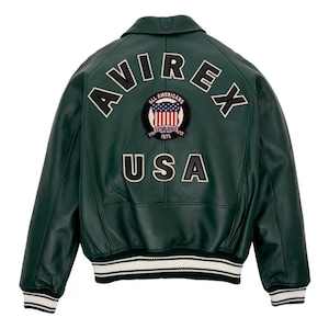 May include: A dark green leather jacket with the text "AVIREX" arched across the upper back, and "USA" below. A patch featuring the American flag is centered between the text. The jacket has a white and black striped hem and cuffs.