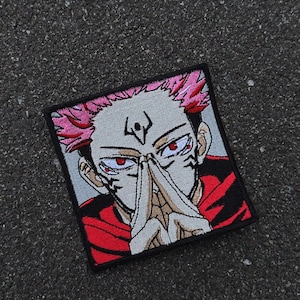 Op de afbeelding: Vierkant geborduurde patch met een anime-personage met roze stekelig haar en rode ogen. Het personage wordt afgebeeld met vingers die het gezicht aanraken. De patch heeft een zwarte rand en een rood-zwarte outfit.