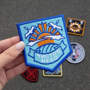 Può includere: Un set di tre tazze in ceramica con smalto screziato color crema. Ogni tazza presenta un design floreale dipinto a mano nei toni del blu, verde e giallo. Le tazze hanno una forma semplice e moderna.