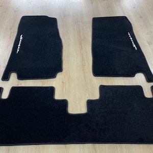 Puede incluir: Un letrero de madera rústico con el texto "Welcome to our home" en letras blancas. El letrero presenta un acabado envejecido y un diseño simple y acogedor, ideal para un porche o entrada.