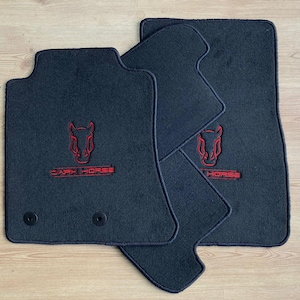 May include: Set of four black car floor mats. Each mat features a red horse head logo and the words "DARK HORSE" embroidered in red. The mats are made of a dark, textured material.