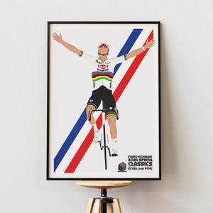 Può includere: Un poster incorniciato raffigurante un ciclista che celebra una vittoria su una bicicletta. Il ciclista indossa un'uniforme bianca e nera con dettagli colorati. Strisce diagonali rosse e blu sono dietro il ciclista. Il testo in basso recita "PARIS-ROUBAIX 2024 SPRING CLASSICS M. VAN DER POEL."