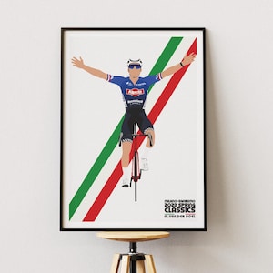 Può includere: Un poster incorniciato con un ciclista in maglia blu con le braccia alzate. Il poster include strisce diagonali verdi e rosse e il testo "MILANO-SANREMO 2023 SPRING CLASSICS M. VAN DER POEL."