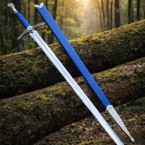 May include: A long, silver sword with a blue handle and crossguard, resting on a moss-covered log. A matching blue sheath lies beside it. The sword has a pointed tip and a silver blade. The background is a blurred forest.