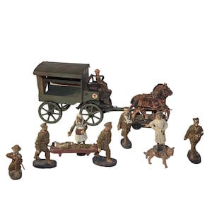 May include: A vintage set of toy soldiers depicting a World War I medical scene. The set includes a horse-drawn ambulance, a stretcher, a doctor, a nurse, and several soldiers. The figures are made of painted metal and are in good condition.