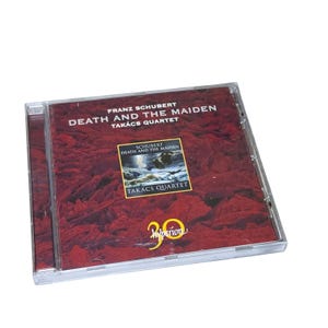 May include: A compact disc case featuring Franz Schubert's Death and the Maiden performed by the Takács Quartet. The cover art displays a deep red textured background with a central rectangular image and the yellow Hyperion 30 logo at the bottom.
