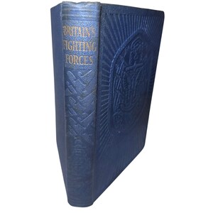 May include: A vintage book titled "Britain's Fighting Forces" with a navy blue cover. The spine features gold lettering, and the cover has an embossed design. The book is in good condition, with slight wear on the edges.