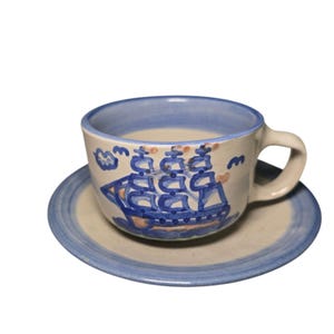 Taza y platillo de cerámica MA Hadley con diseño de velero alto y marea baja.
