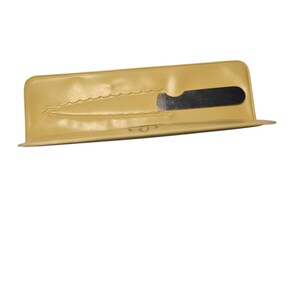 May include: A tan-colored knife sheath with a black knife blade partially visible. The sheath has a textured surface and a scalloped edge. The knife is designed to fit snugly within the sheath.