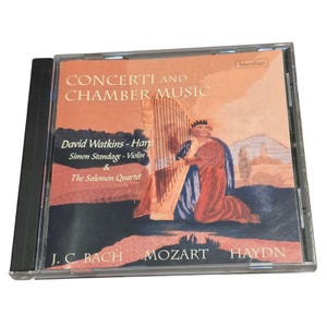 May include: A compact disc case featuring an orange and dark blue cover with the text Concerti and Chamber Music, David Watkins - Harp, Simon Standage - Violin & The Salomon Quartet, and J.C. Bach, Mozart, Haydn, depicting a person playing a harp.