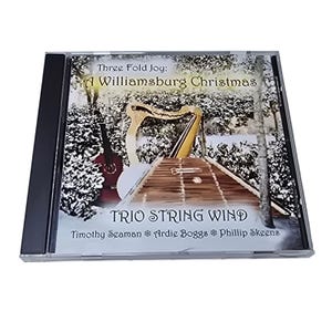 May include: A CD case featuring the album "Three Fold Joy: A Williamsburg Christmas" by Trio String Wind. The cover art depicts a winter scene with musical instruments, including a harp and dulcimer. The CD case is in a black plastic case.