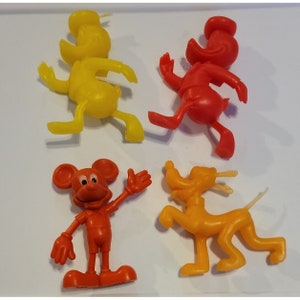 Könnte beinhalten: Ein Set mit vier Vintage-Plastikfiguren von Disney-Charakteren. Die Figuren sind Mickey Mouse, Donald Duck, Goofy und Pluto. Mickey Mouse ist rot, Donald Duck ist rot, Goofy ist gelb und Pluto ist gelb.
