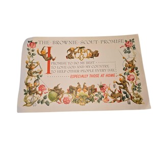 May include: Vintage print of "The Brownie Scout Promise" with whimsical illustrations of brownies, flowers, and vines. The text includes the promise to do one's best, love God and country, and help others. The print has a cream-colored background.