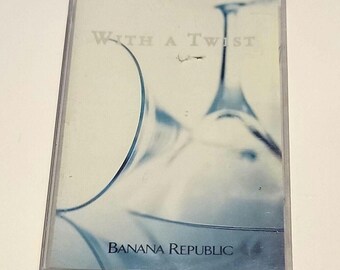Könnte beinhalten: Ein Kassettenband mit einem abstrakten Design in Blau und Weiß. Der Text "With a Twist" und "Banana Republic" ist auf der Vorderseite des Bandes aufgedruckt.
