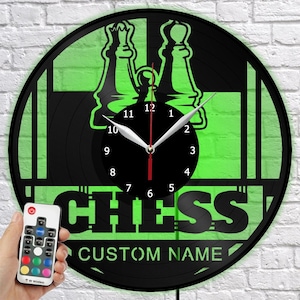 May include: Black and green chess-themed wall clock with a custom name option. The clock features a chess piece design and the word "CHESS". Includes a remote control for the LED lighting.