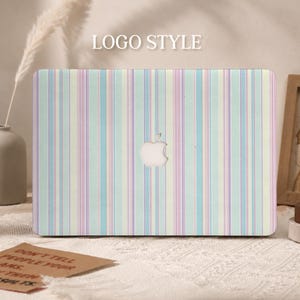 May include: A laptop skin featuring a vertical striped pattern in pastel shades of light blue, pale pink, and cream. The design covers the exterior surface of a laptop, which displays a centered white Apple logo. The text LOGO STYLE is visible.
