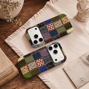 Puede incluir: Dos fundas para smartphone con un diseño de patchwork de varios cuadrados de tela en tonos verdes, azules, morados y rojos con patrones florales, de cuadros y de lunares. Cada funda tiene un recorte rectangular para la cámara con tres lentes.