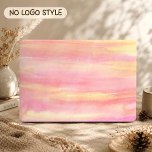May include: A rectangular laptop skin featuring a soft watercolour wash in shades of pastel pink, peach, and pale yellow. The design displays horizontal, blended brushstrokes across the entire surface, creating a smooth, gradient effect.