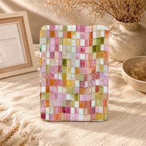 May include: A rectangular tablet case featuring a grid pattern of small, glossy squares in shades of pink, orange, yellow, olive green, and white. The surface has a reflective, glass-like finish with a repeating mosaic design.