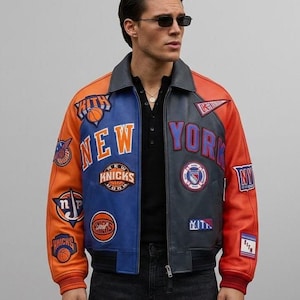 May include: A multi-colored leather varsity jacket featuring orange sleeves and a split blue and grey front panel. The jacket is adorned with various embroidered patches including New York Knicks logos, Kith branding, and basketball graphics.