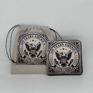May include: A beige drawstring bag and a square wallet featuring a patriotic design. The design includes an eagle, stars, and the text "250 YEARS AMERICA 1776-2026 CELEBRATING FREEDOM". The wallet is black.