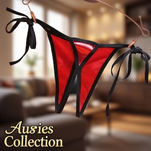 May include: Red and black lingerie with tie closures. The lingerie is a vibrant red with black trim and black ties at the sides. The text "Ausies Collection" is visible in the bottom left corner.