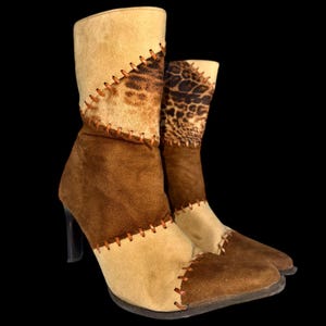Peut inclure: Bottes de cheville élégantes avec un design patchwork unique. Les bottes présentent une combinaison de panneaux beiges, marron et imprimé léopard, cousus avec du fil marron visible. Elles ont un talon haut et un bout pointu.