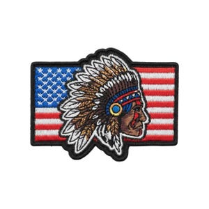 Puede incluir: Parche bordado con un jefe nativo americano de perfil, con un tocado de plumas. El jefe se encuentra sobre un fondo de la bandera estadounidense. El parche tiene un borde negro.