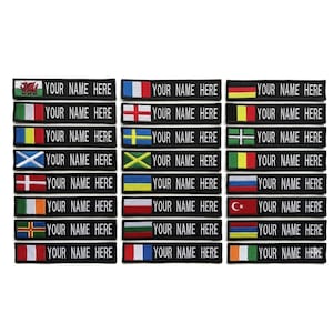 May include: A collection of black embroidered patches, each featuring a different flag design and the text "YOUR NAME HERE". Flags include those of Wales, France, Germany, Italy, England, Sweden, Switzerland, Scotland, and more.