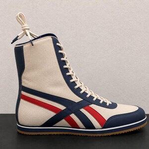 Profile view of a single high-top white leather wrestling boot featuring blue and red stripes, white laces, and a gum rubber sole.