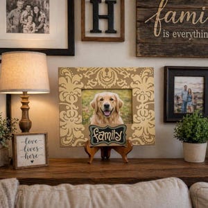 May include: A display of framed family photographs and a framed picture of a golden retriever. A wooden sign with the word "Family" is displayed in front of the dog's photo. A lamp and other decorative items are also present.